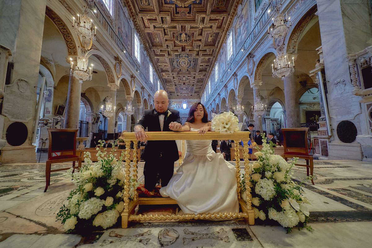 Bride and groom kneeling during wedding at S. Maria in Aracoeli in Rome
