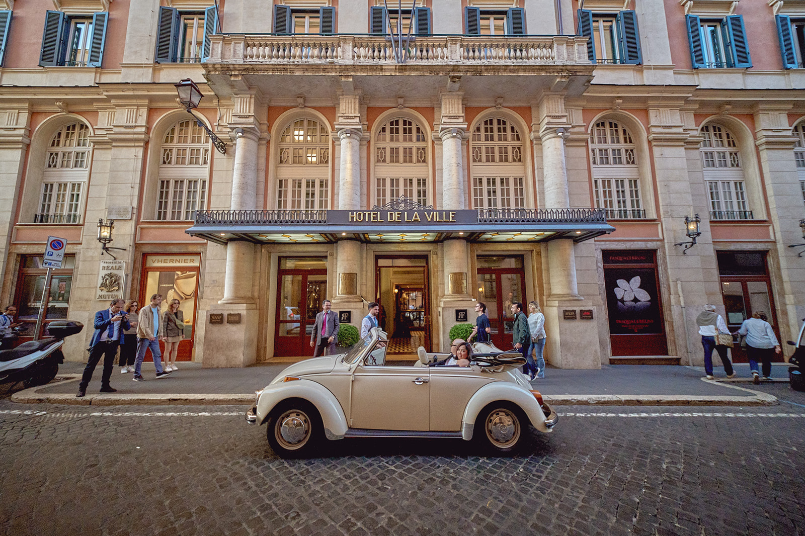 Newlyweds arriving in Beetle at Hotel De La Ville, Rome